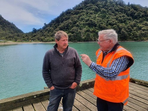 Councillor Ian Hartshorne and John Bainbridge, Transportation Officer on Jackson Bay Wharf with hills behind them.